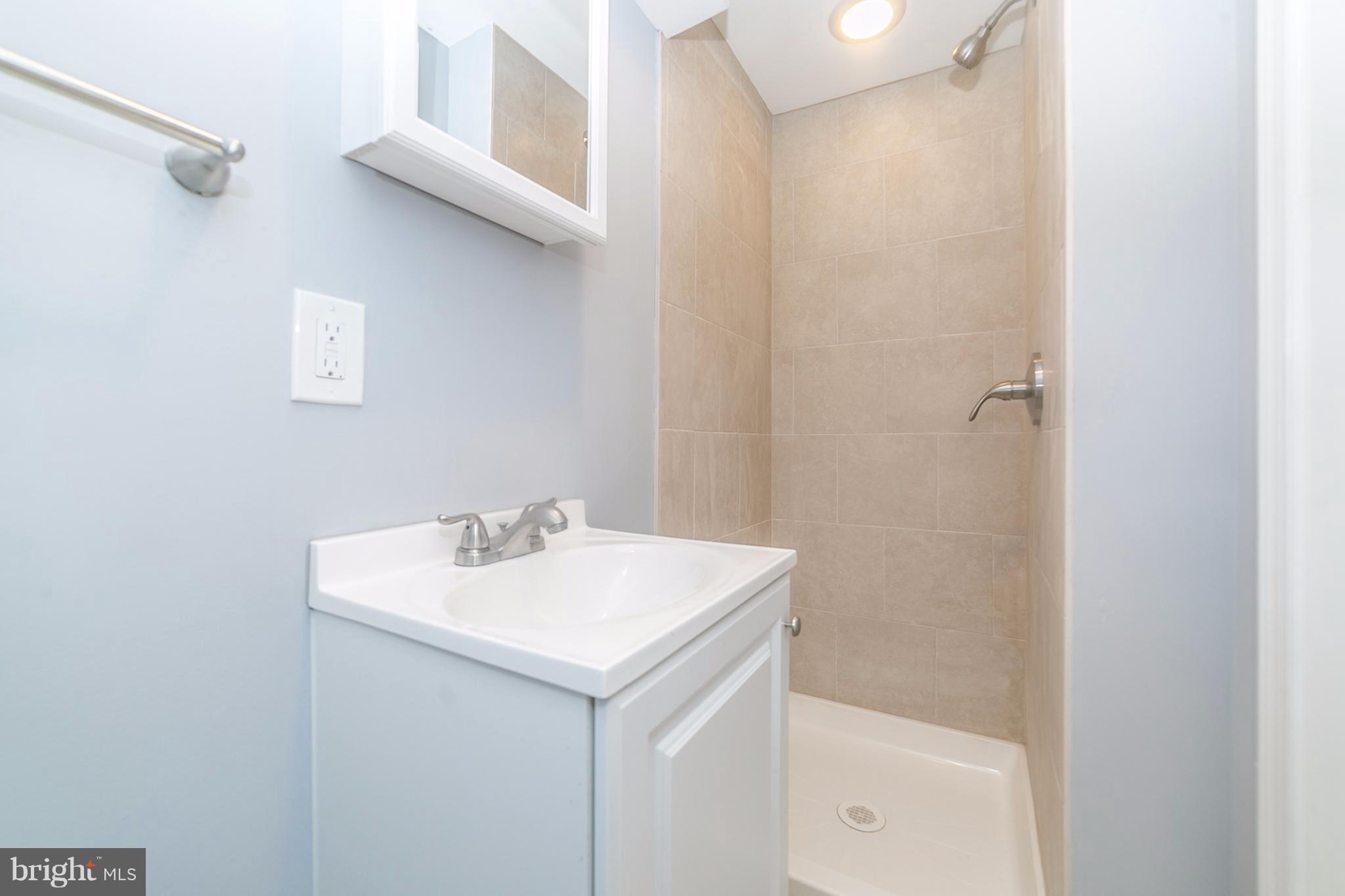 7436 Edsworth Road Baltimore, MD 21222 - Photo 22 of 30 a bathroom with a sink a mirror and a bathtub