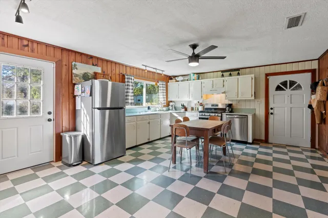 a kitchen with stainless steel appliances granite countertop a refrigerator and a stove top oven