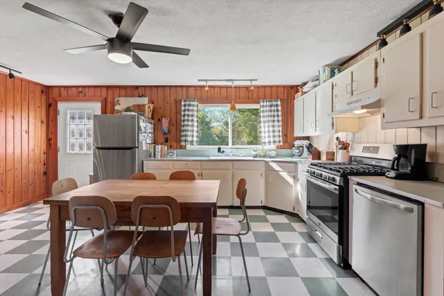 a kitchen with stainless steel appliances granite countertop a stove a sink a microwave oven with a dining table and chairs