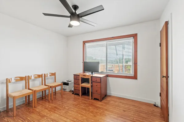 a view of a workspace with furniture and a window