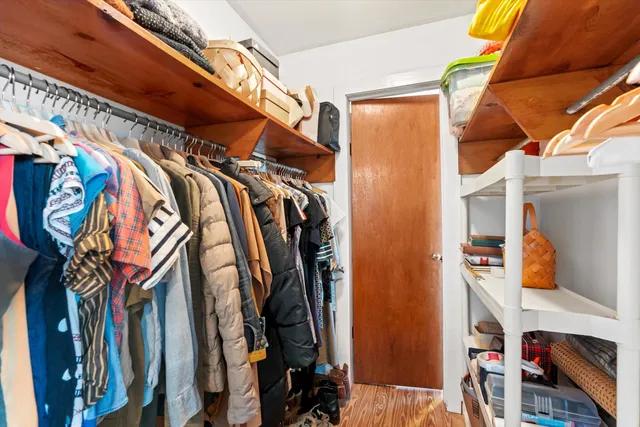 a view of walk in closet with clothes and shoes