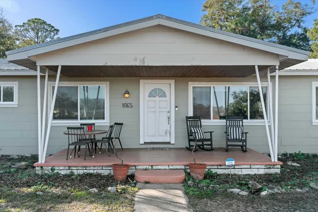 a house view with outdoor seating space and garden