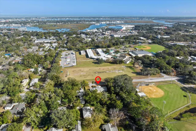 an aerial view of residential houses with outdoor space and swimming pool