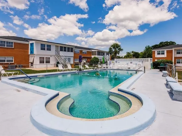 a view of a house with swimming pool and sitting area