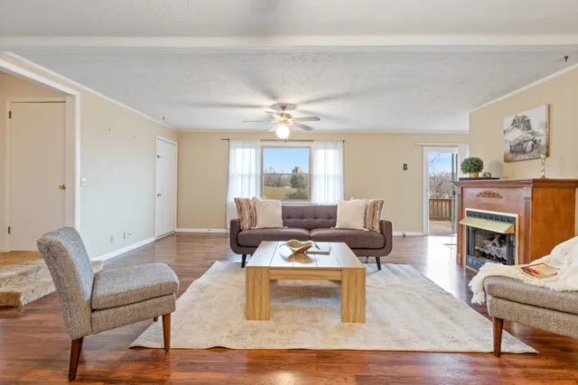 a living room with furniture a fireplace and a window