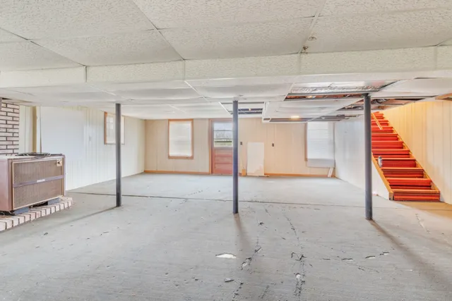 a view of a house with a yard covered with snow and trees
