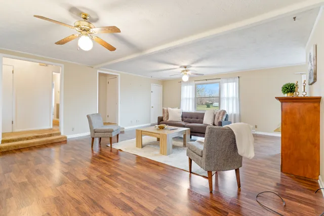 a living room with furniture a table and wooden floor