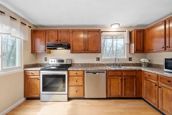 a kitchen with stainless steel appliances granite countertop a stove sink and cabinets