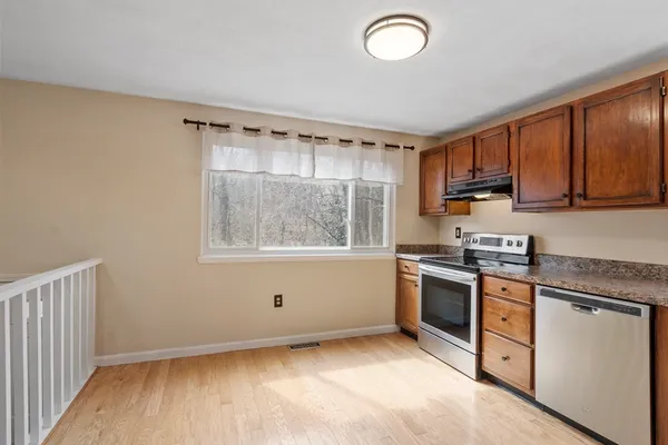 a kitchen with granite countertop a stove a sink and a refrigerator