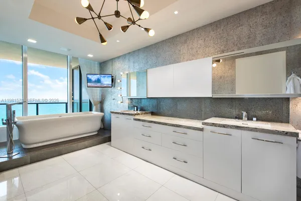 a kitchen with a white cabinets and chandelier