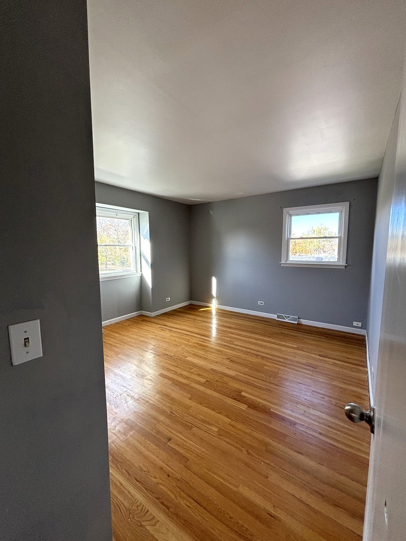 991 Spring Road Elmhurst, IL 60126 - Photo 11 of 17 a view of empty room with wooden floor and fan