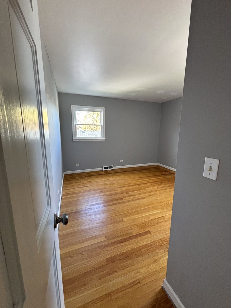 991 Spring Road Elmhurst, IL 60126 - Photo 12 of 17 a view of an empty room with wooden floor and a window