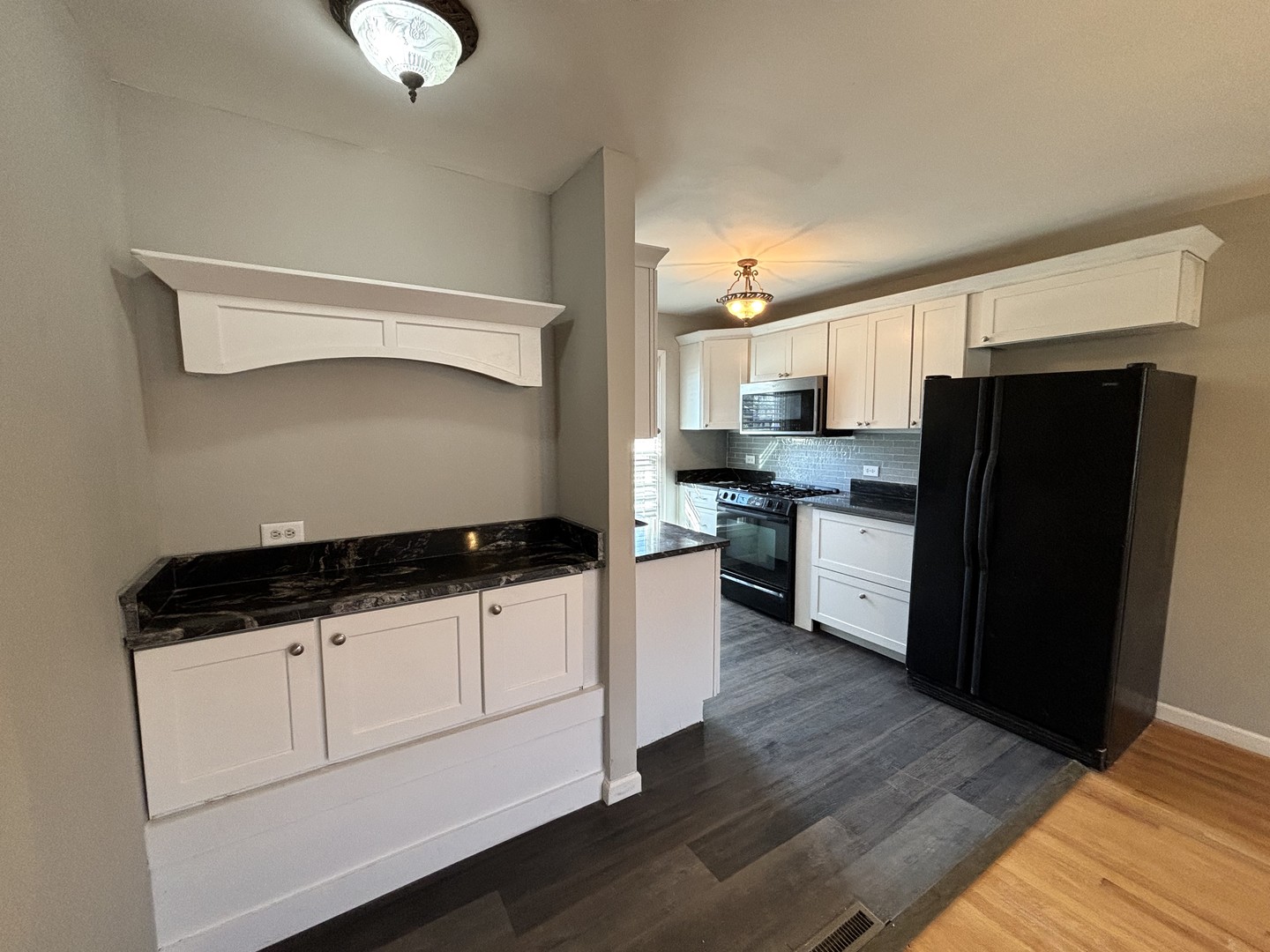 991 Spring Road Elmhurst, IL 60126 - Photo 5 of 17 a kitchen with granite countertop a refrigerator a stove a sink and white cabinets with wooden floor