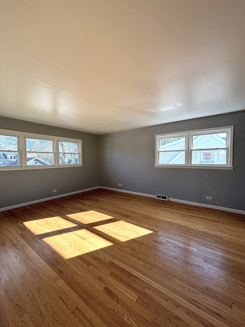 991 Spring Road Elmhurst, IL 60126 - Photo 8 of 17 a view of empty room with wooden floor and fan