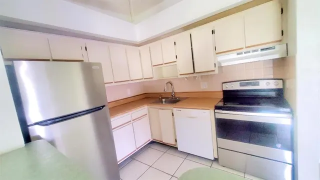 a kitchen with stainless steel appliances a refrigerator sink and cabinets