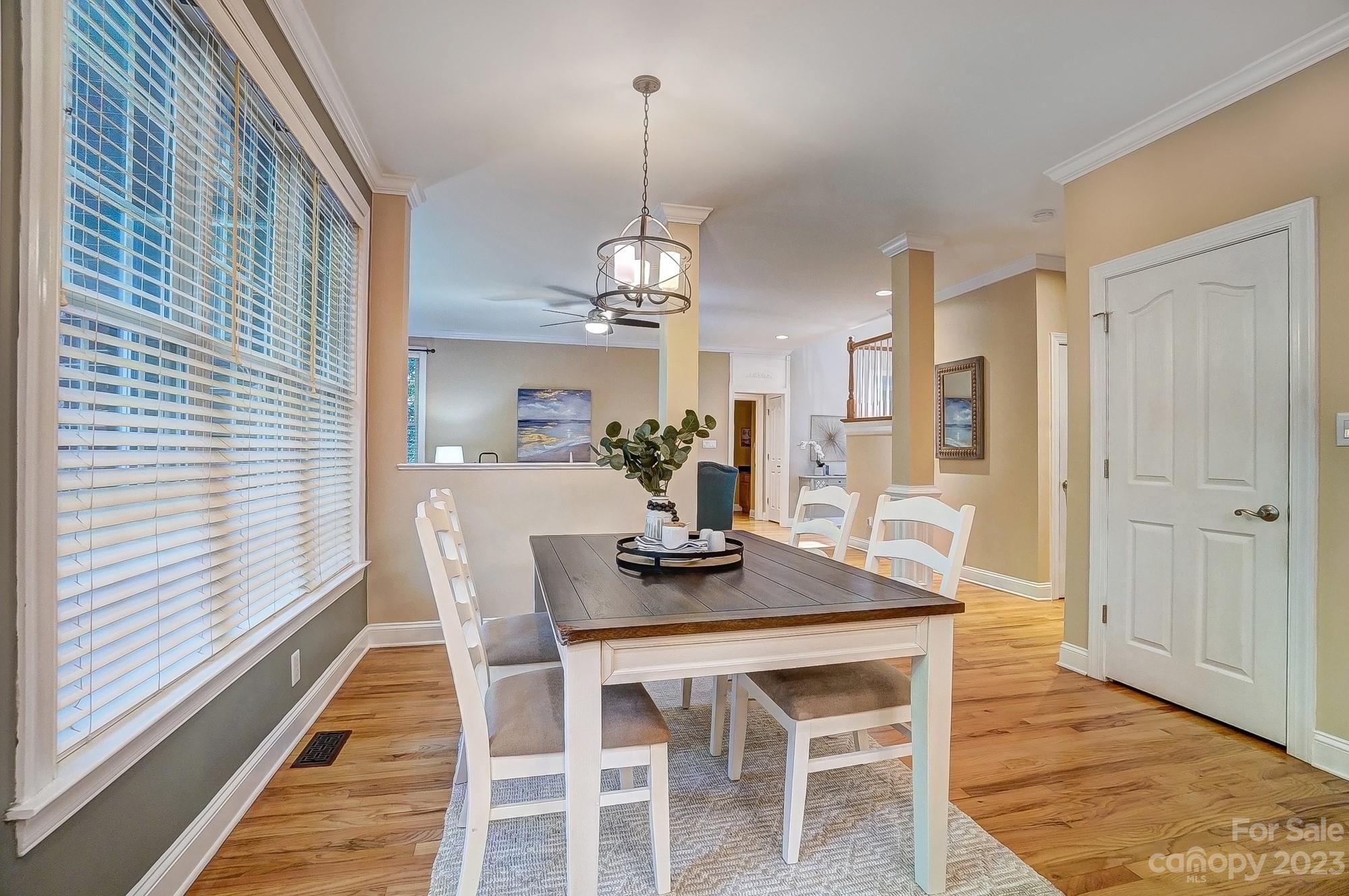 9710 Shadowmere Lane Weddington, NC 28104 - Photo 14 of 46 a dining room with furniture a chandelier and wooden floor