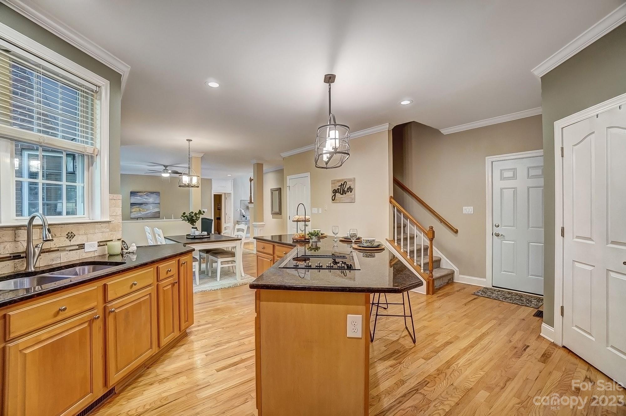 9710 Shadowmere Lane Weddington, NC 28104 - Photo 17 of 46 a large kitchen with kitchen island a sink a stove a dining table and chairs