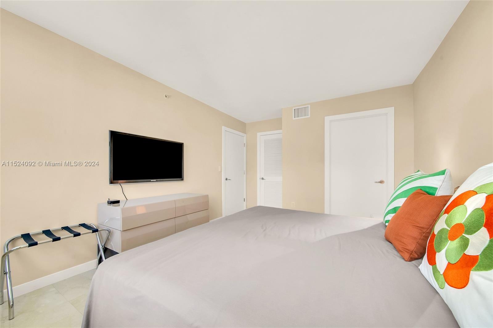 90 Alton Road, Unit 902 Miami Beach, FL 33139 - Photo 13 of 35 a bedroom with a bed and a flat screen tv