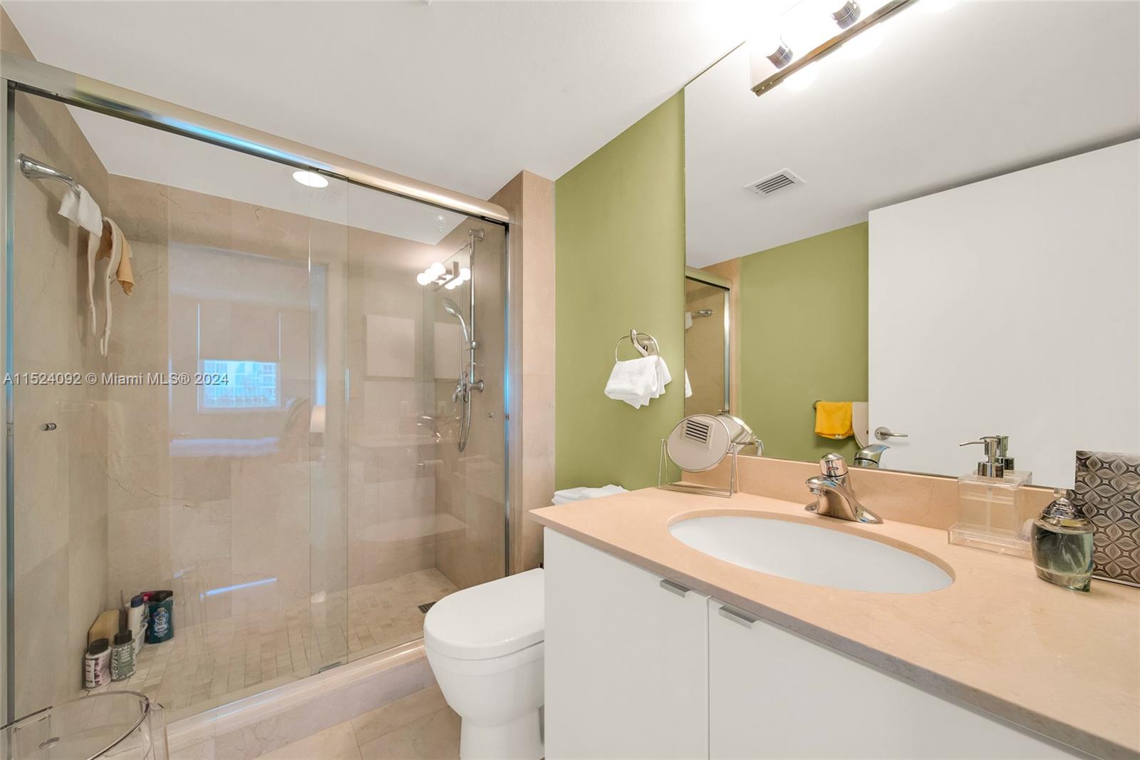 90 Alton Road, Unit 902 Miami Beach, FL 33139 - Photo 14 of 35 a bathroom with a granite countertop sink a toilet and shower