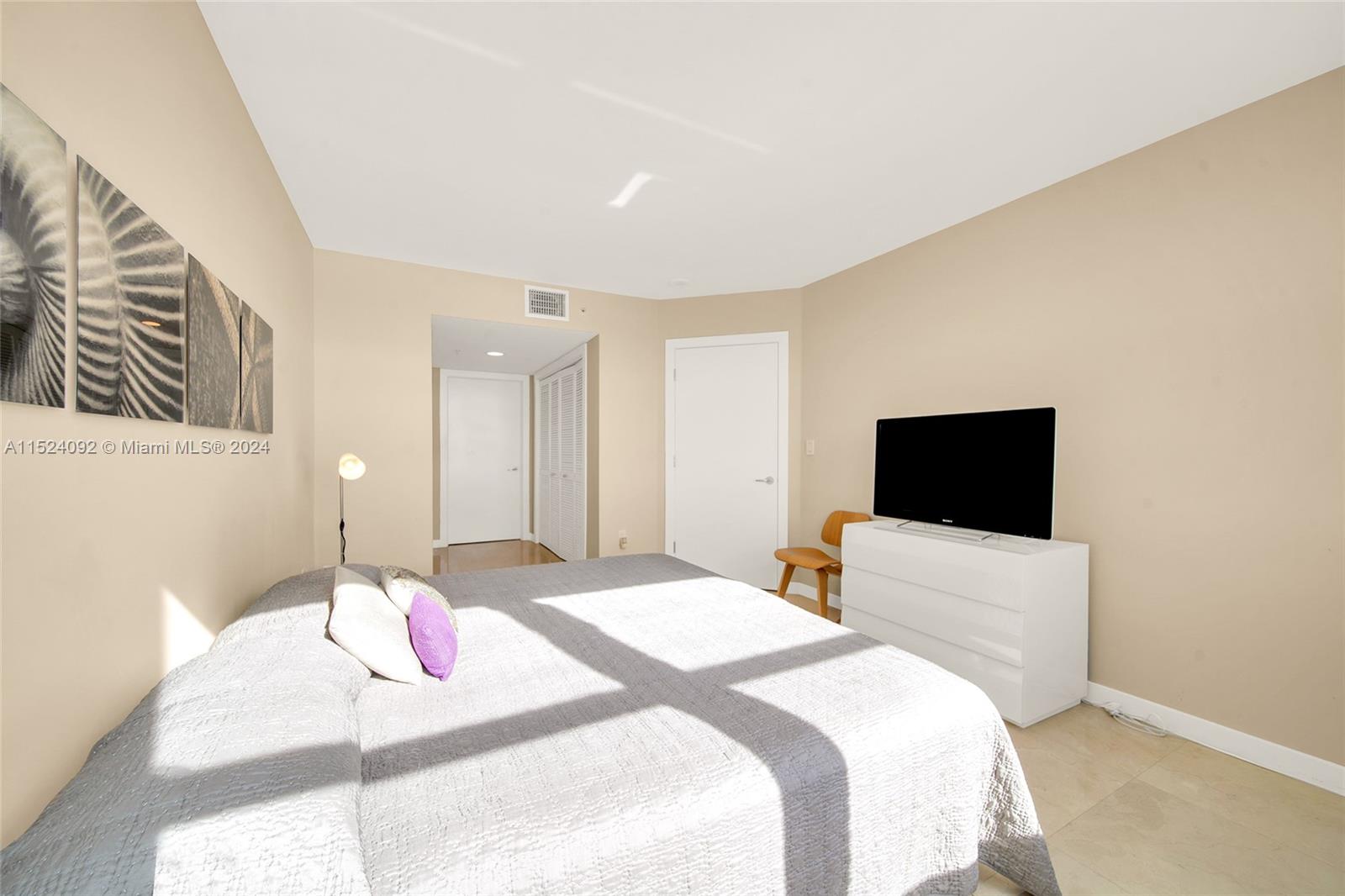 90 Alton Road, Unit 902 Miami Beach, FL 33139 - Photo 22 of 35 a bedroom with a bed and a flat screen tv