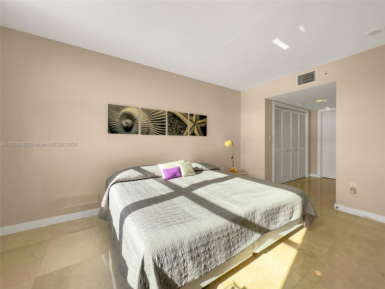 90 Alton Road, Unit 902 Miami Beach, FL 33139 - Photo 23 of 35 a bedroom with a bed and painting on the wall