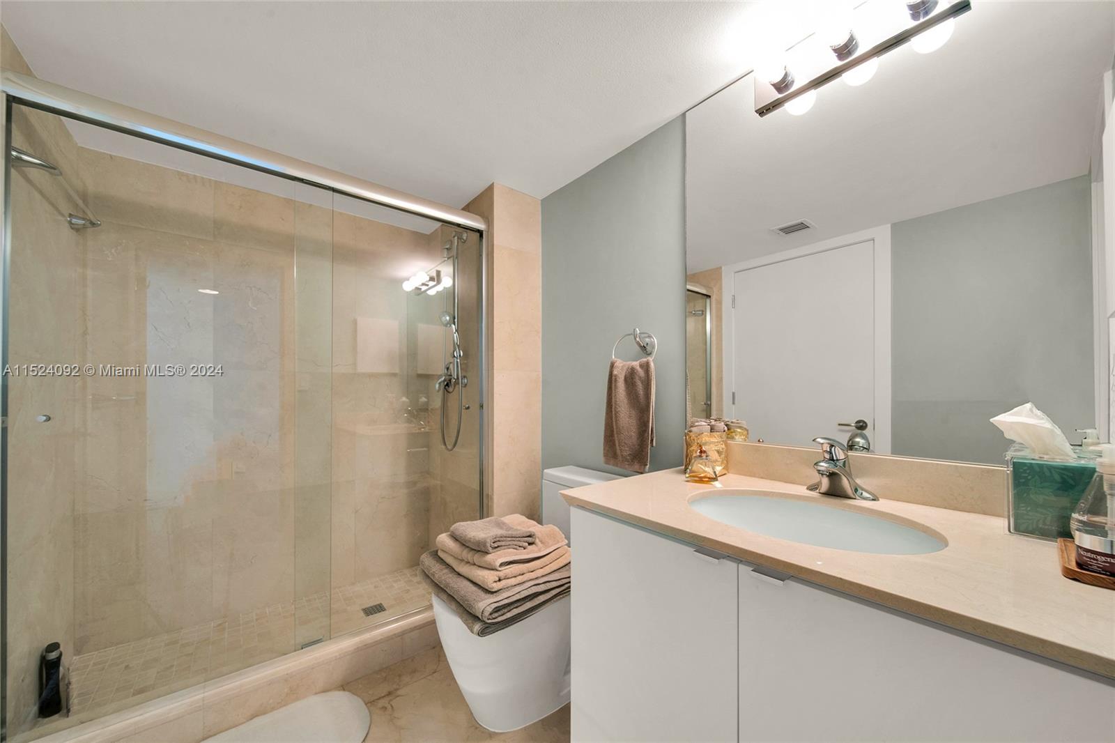 90 Alton Road, Unit 902 Miami Beach, FL 33139 - Photo 24 of 35 a bathroom with a sink a toilet and shower