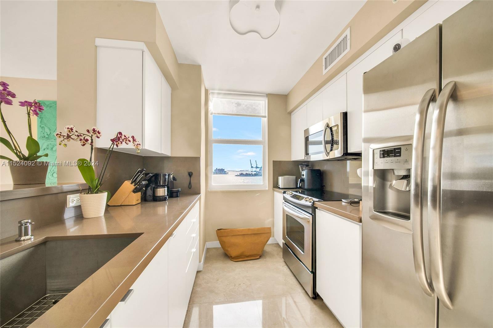 90 Alton Road, Unit 902 Miami Beach, FL 33139 - Photo 4 of 35 a kitchen with stainless steel appliances granite countertop a sink a stove and a refrigerator