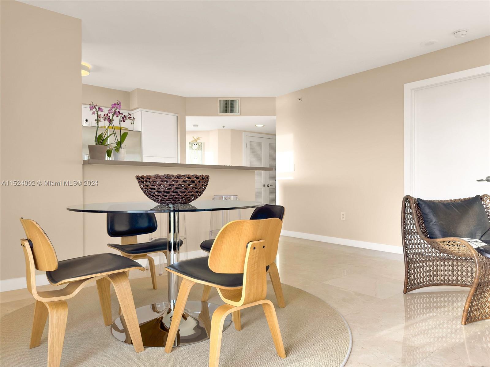 90 Alton Road, Unit 902 Miami Beach, FL 33139 - Photo 7 of 35 a view of a dining room with furniture and wooden floor