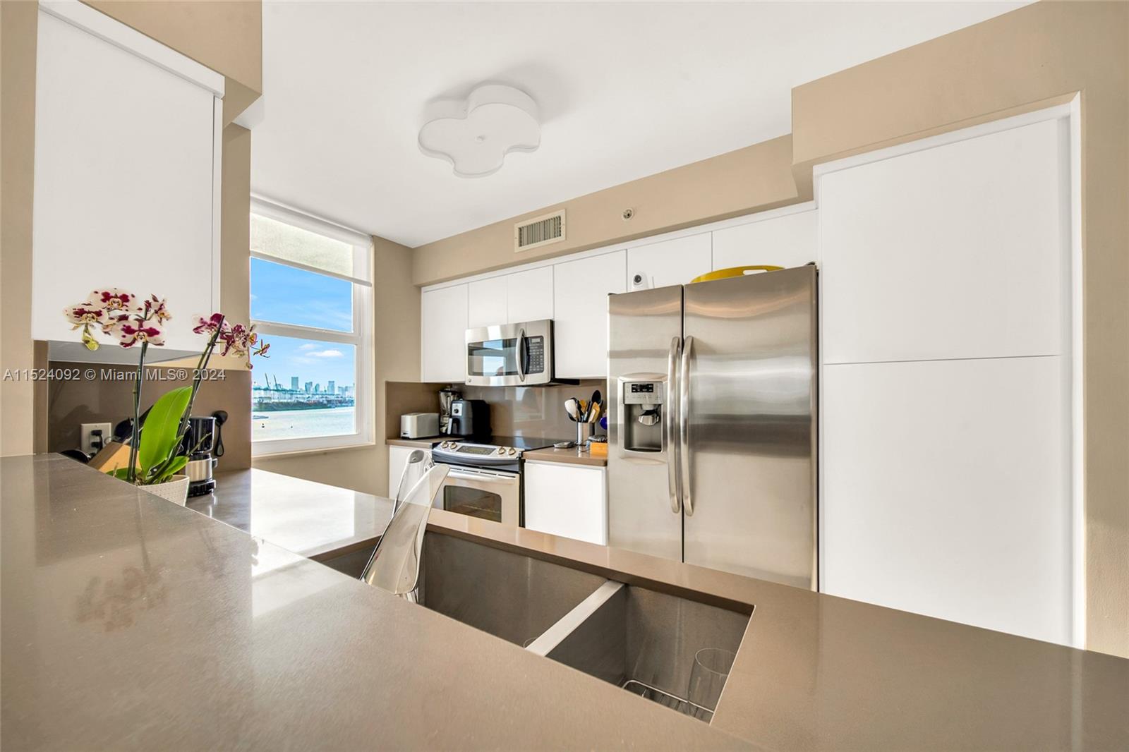 90 Alton Road, Unit 902 Miami Beach, FL 33139 - Photo 9 of 35 a kitchen with kitchen island a counter top space cabinets and stainless steel appliances