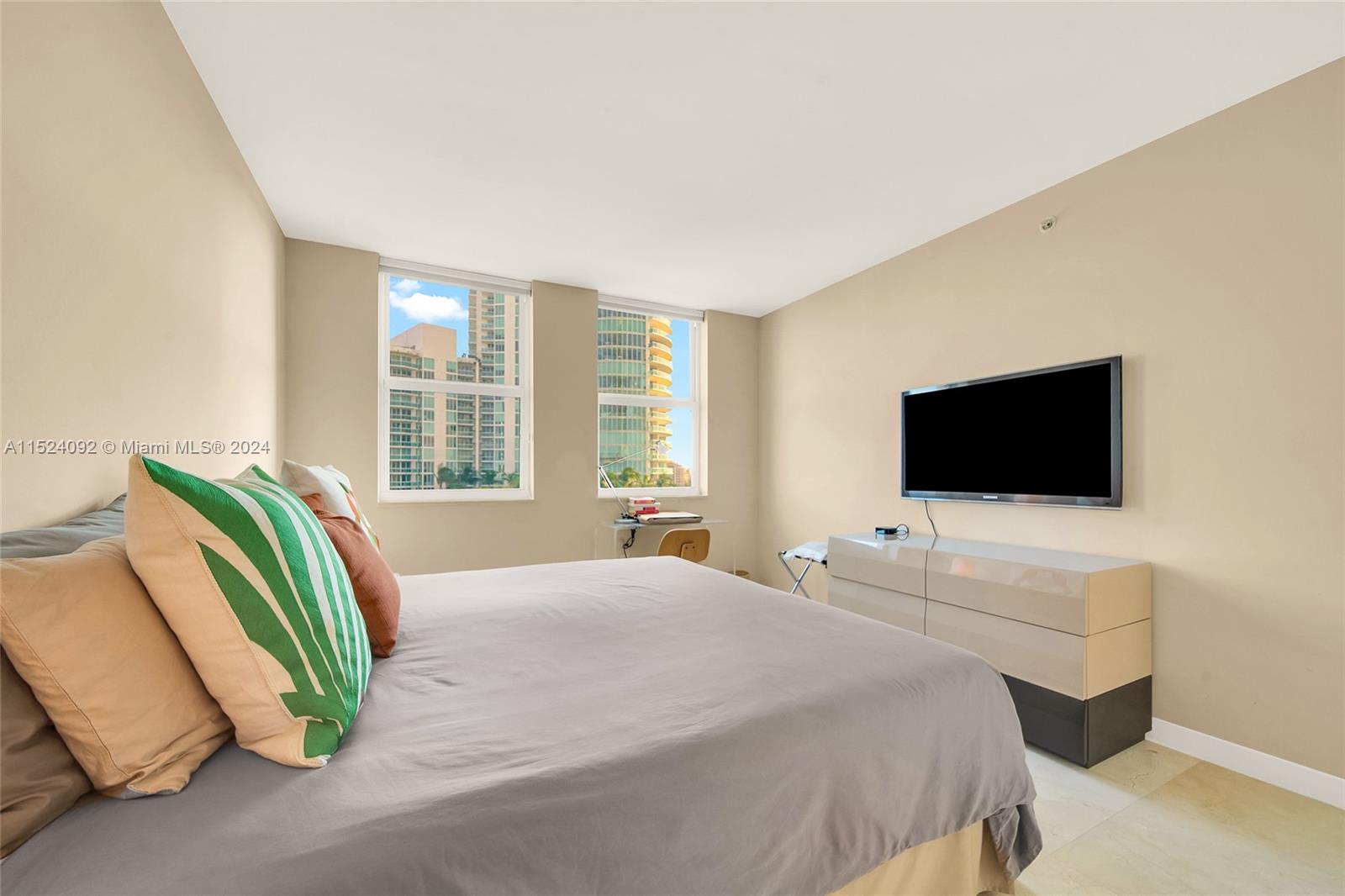 90 Alton Road, Unit 902 Miami Beach, FL 33139 - Photo 10 of 35 a bedroom with a bed and a television