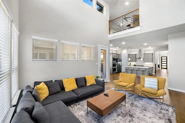 a living room with furniture wooden floor and a large window