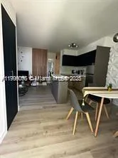 a kitchen with a table chairs a stove and a microwave