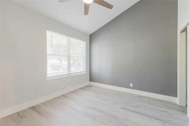 an empty room with a window and wooden floor