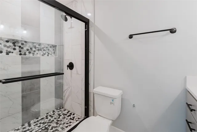 a bathroom with a toilet and a shower