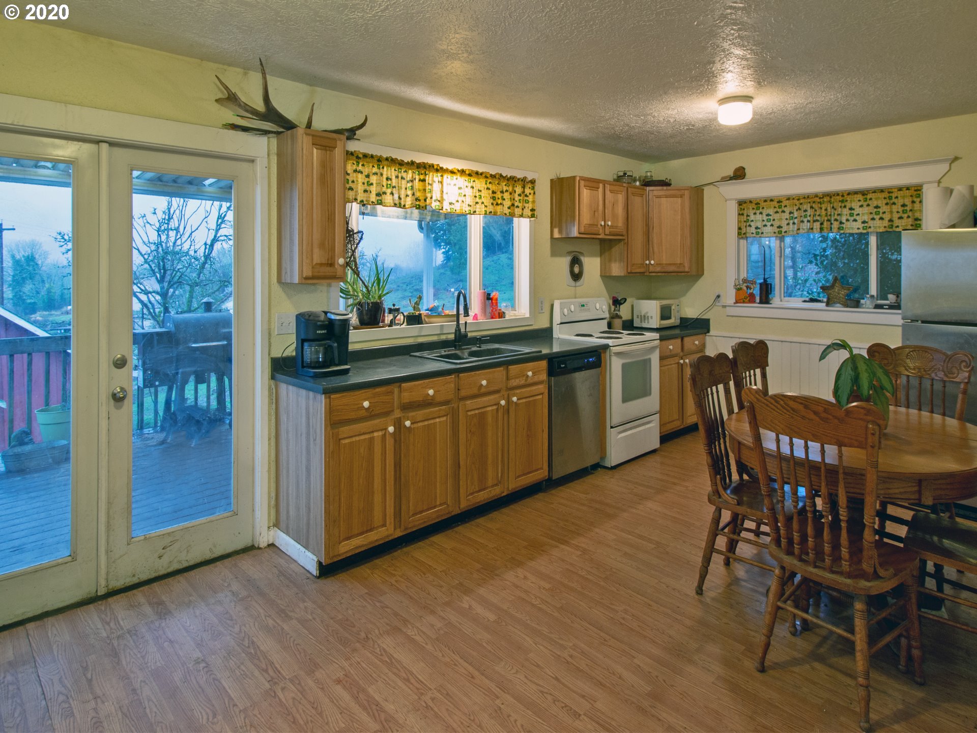 18711 Beaver Falls Road Clatskanie, OR 97016 - Photo 6 of 14 a kitchen with stainless steel appliances granite countertop wooden floors and white cabinets
