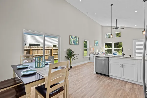 a living room with furniture a dining table and chairs with wooden floor