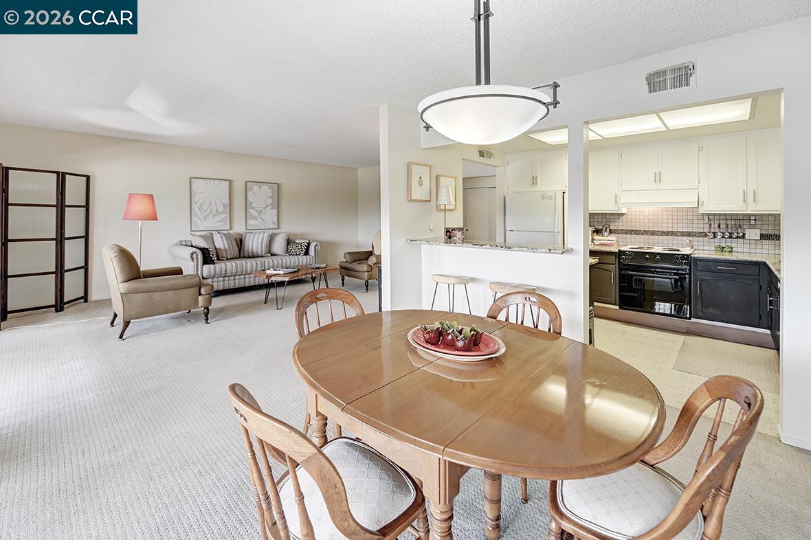 1548 Golden Rain Road, Unit 9 Walnut Creek, CA 94595 - Photo 19 of 45 a kitchen with stainless steel appliances granite countertop a dining table and chairs