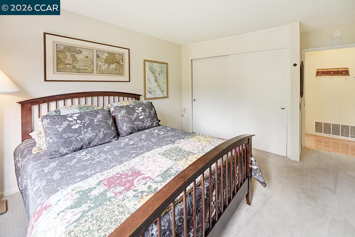 1548 Golden Rain Road, Unit 9 Walnut Creek, CA 94595 - Photo 29 of 45 a bedroom with a large bed and a chandelier