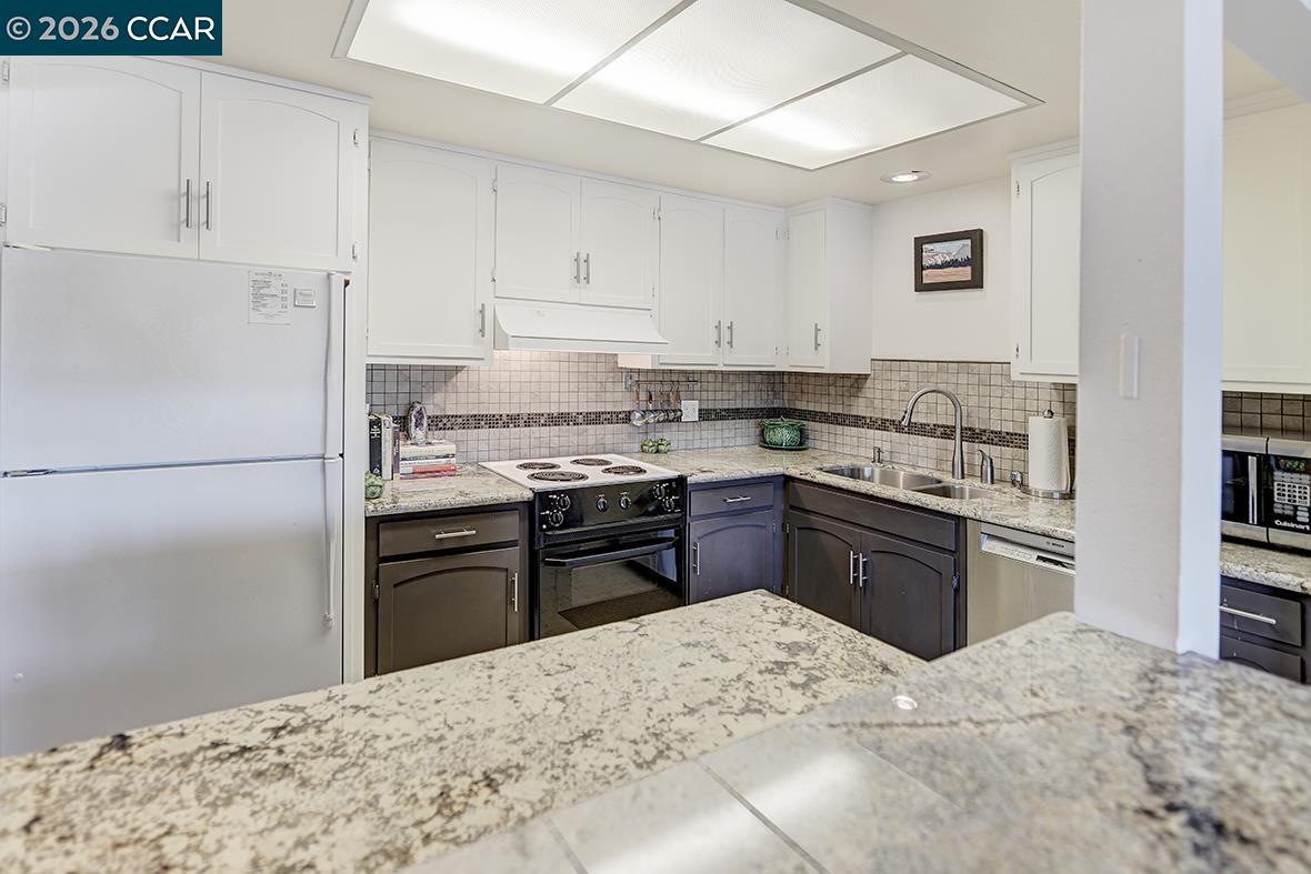 1548 Golden Rain Road, Unit 9 Walnut Creek, CA 94595 - Photo 9 of 45 a kitchen with granite countertop a refrigerator stove top oven and sink