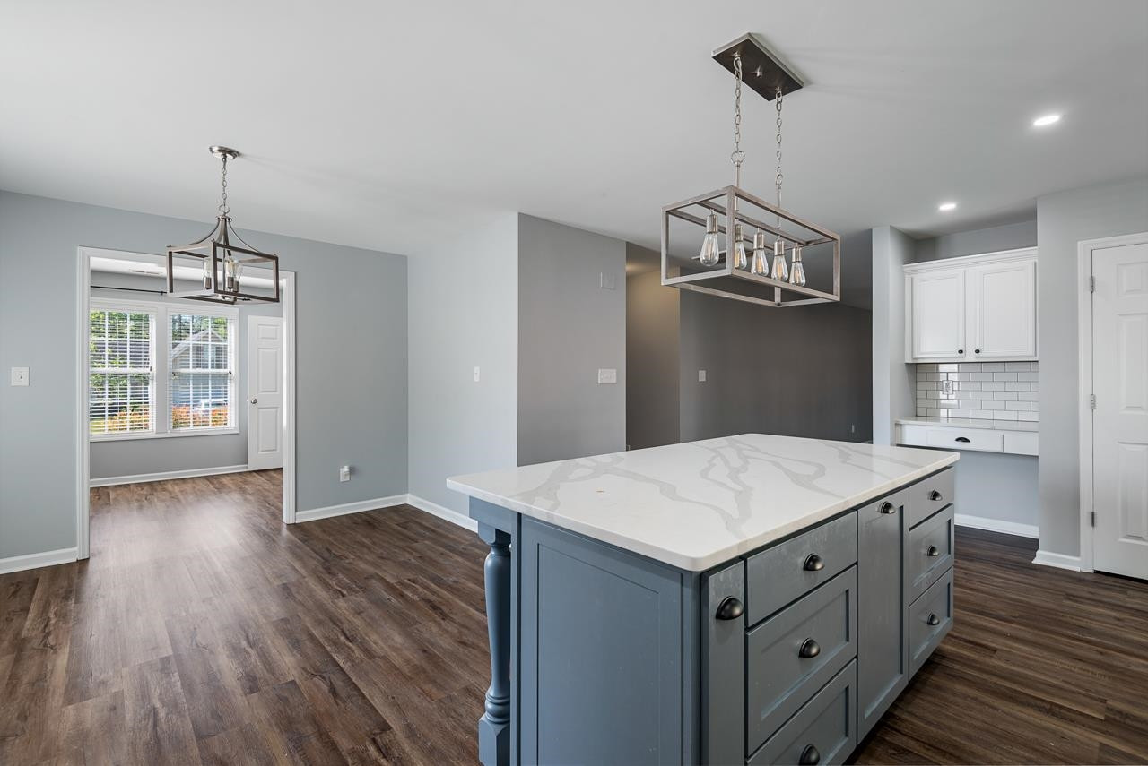 308 Saranac Ridge Drive Holly Springs, NC 27540 - Photo 13 of 41 a kitchen with kitchen island stainless steel appliances a table chairs and chandelier