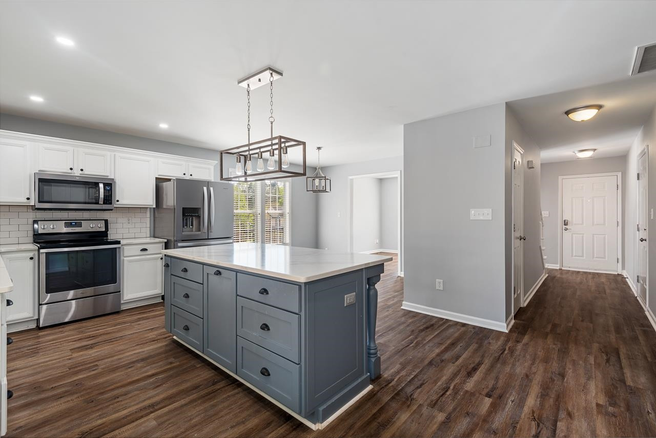 308 Saranac Ridge Drive Holly Springs, NC 27540 - Photo 14 of 41 a kitchen with granite countertop a sink and a stove top oven