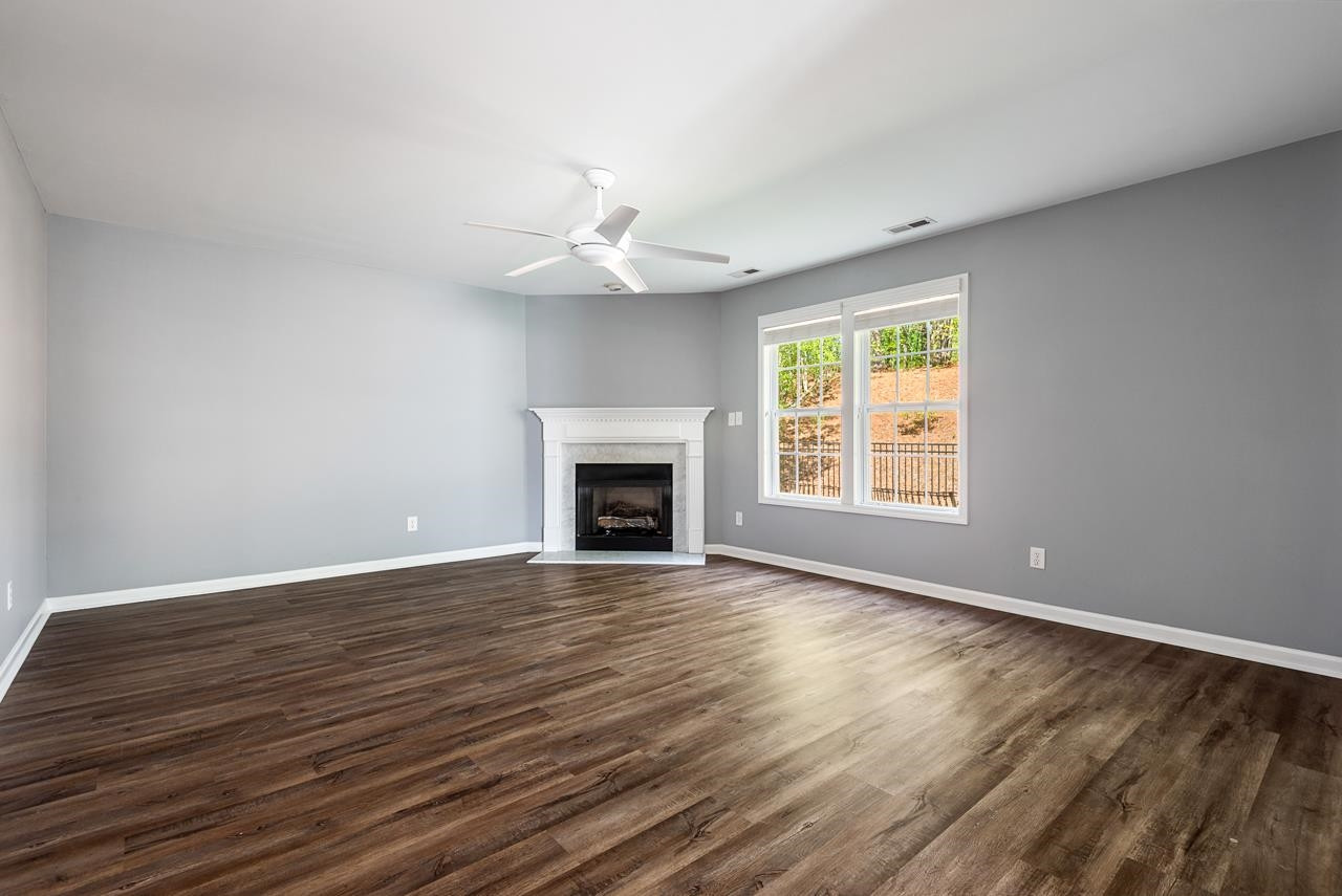 308 Saranac Ridge Drive Holly Springs, NC 27540 - Photo 18 of 41 an empty room with wooden floor fireplace and windows