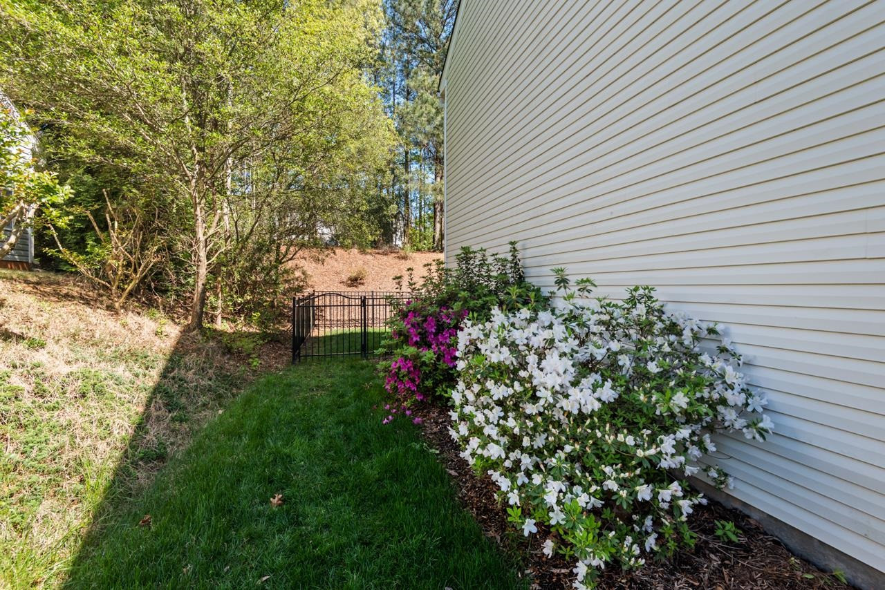 308 Saranac Ridge Drive Holly Springs, NC 27540 - Photo 34 of 41 a view of a backyard with plants and a flower garden