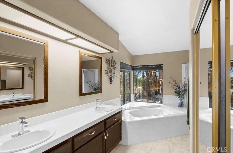 42050 Humber Drive Temecula, CA 92591 - Photo 17 of 31 a bathroom with a tub a double vanity sink and mirror