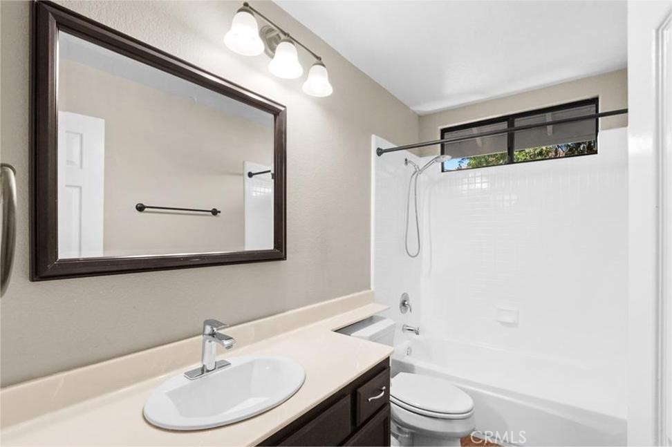 42050 Humber Drive Temecula, CA 92591 - Photo 29 of 31 a bathroom with a toilet a sink a mirror a vanity and shower