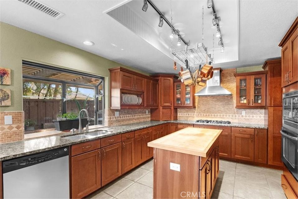42050 Humber Drive Temecula, CA 92591 - Photo 8 of 31 a kitchen with a sink a center island a counter space and stainless steel appliances