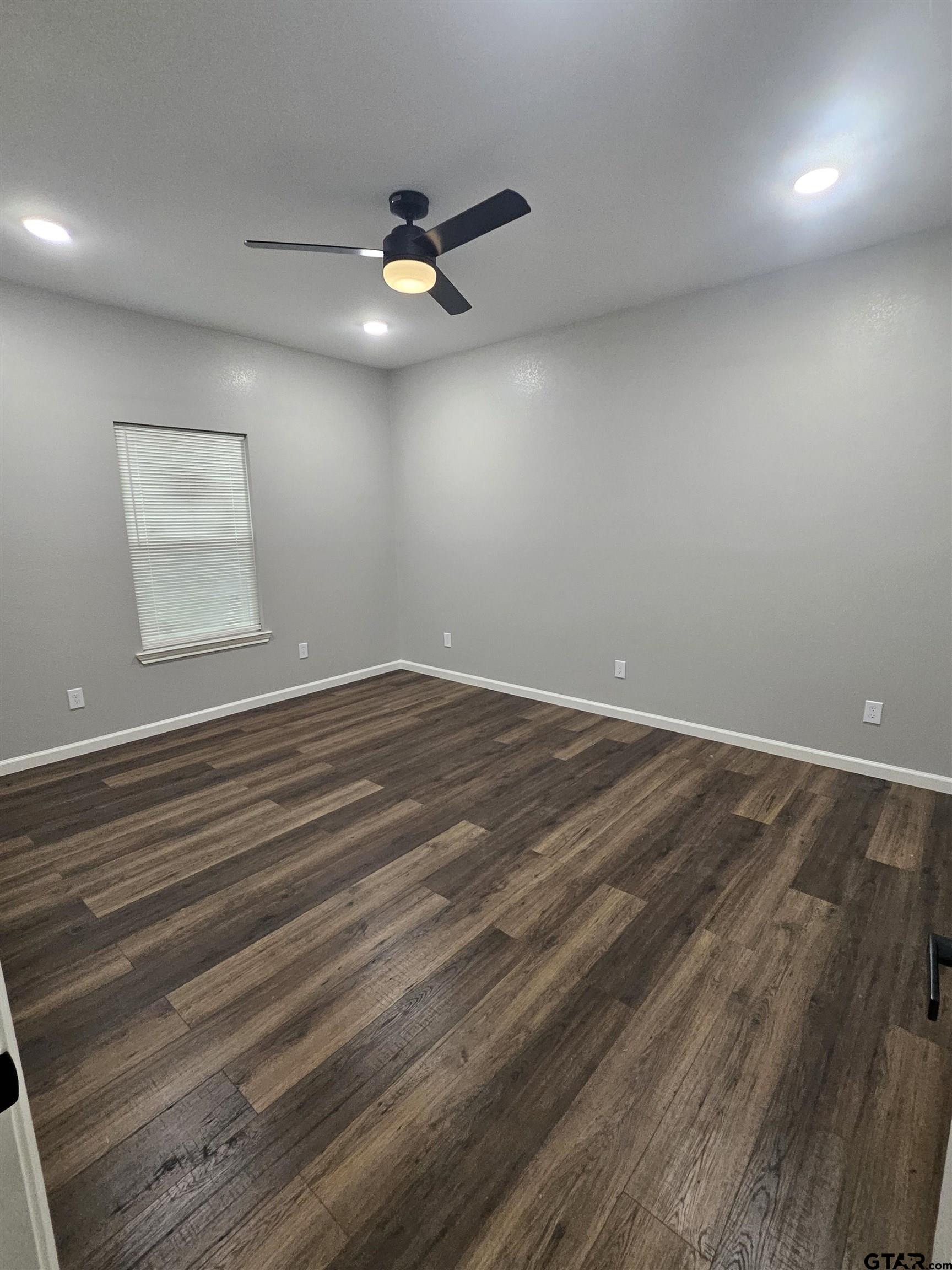 1399 West 2nd Tyler, TX 75701 - Photo 6 of 11 an empty room with wooden floor fan and windows