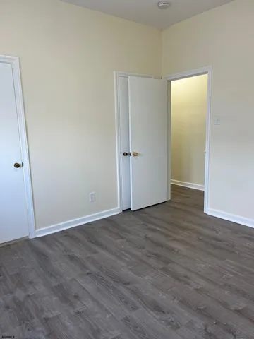 an empty room with wooden floor and closet