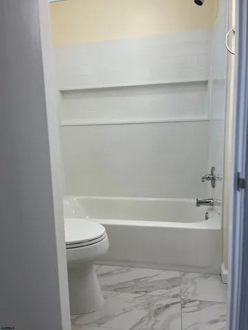 a bathroom with a toilet and a bath tub