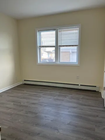 a view of a room with wooden floor and a window